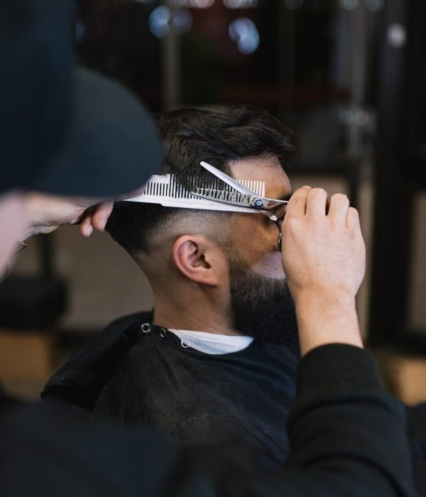 Barber schneidet einem Kunden im RenneTheBarber Barbershop in Zirndorf die Haare mit der Schere